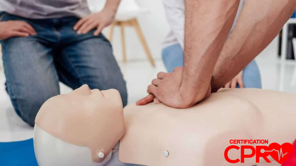 CPR training session with a man practicing on a mannequin in Boston.